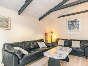 a living room with a leather couch and a table at 4 star holiday home in Hals in Hals