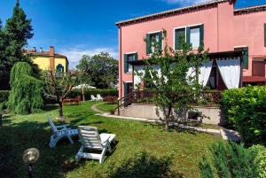 einen Hof mit einem rosa Haus und einem Stuhl in der Unterkunft B&B 500 in Lido di Venezia