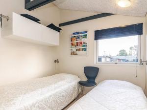 a bedroom with a bed and a chair and a window at 4 star holiday home in Hals in Hals +30 photos