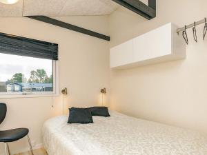 a bedroom with a white bed and a window at 4 star holiday home in Hals in Hals