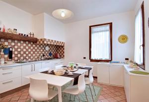 a kitchen with white cabinets and a table and chairs at Villa Dacri in Venice-Lido