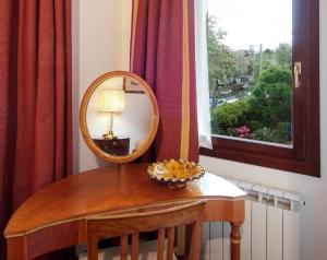 einen Spiegel auf einem Tisch in einem Zimmer mit Fenster in der Unterkunft B&B 500 in Lido di Venezia