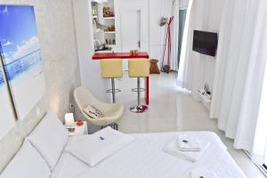 a white bedroom with a white bed and a red counter at Mavres Luxury Studio in Ágios Matthaíos