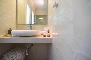a bathroom with a white sink and a mirror at Mavres Luxury Studio in Ágios Matthaíos +15 photos