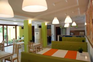 a restaurant with green and orange walls and tables and chairs at Green Hisar Hotel Family in Hisarya