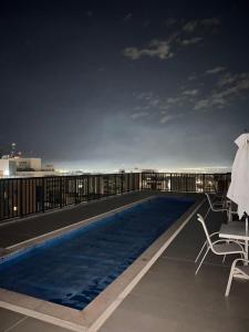 a swimming pool on the roof of a building at night at Nobile Suites, Flats Rocha in Brasília
