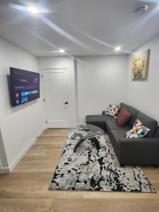 un salon avec un canapé et une télévision à écran plat dans l'établissement Home in Calgary, à Calgary