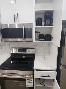 une cuisine avec une cuisinière et un micro-ondes dans l'établissement Home in Calgary, à Calgary