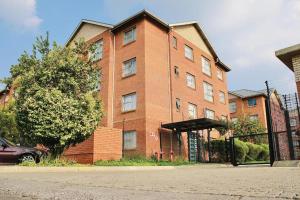 a brick building with a car parked in front of it at Modern Style Apartments, An Escape From The City in Pretoria