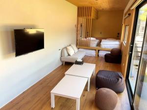 a living room with a couch and a tv at 佐渡風流 nagomi in Sado