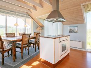 a kitchen and dining room with a table and a stove at 8 person holiday home in Løkken-By Traum in Løkken