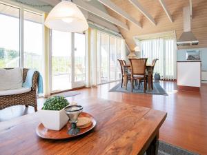 a living room with a wooden table and chairs at 8 person holiday home in Løkken-By Traum in Løkken
