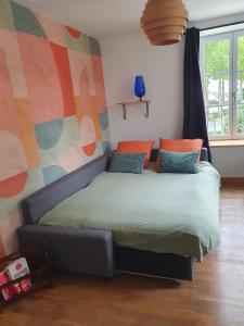a bed in a bedroom with a colorful wall at Vinyle club-rétro 70's-6 pers-Terrasse-Wifi-Parking in Bellême