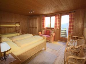 a bedroom with two beds and a couch and a chair at Chalet in Vorarlberg in Egg