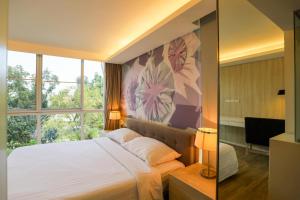 ein Schlafzimmer mit großem Bett und Fenster in der Unterkunft The Idle Hotel and Residence in Pathum Thani