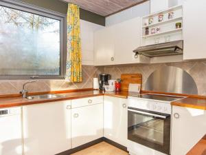 Roeにある6 person holiday home in Ans Byの白いキャビネット、シンク、窓付きのキッチン +13枚の写真