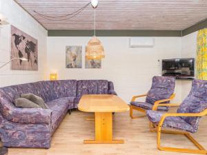 Roeにある6 person holiday home in Ans Byのリビングルーム(紫色のソファ、椅子2脚付)