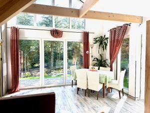 a dining room with a table and chairs and windows at Bocian nad Bugiem in Mierzwice