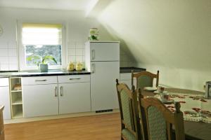 a kitchen with a table and a white refrigerator at Ferienwohnung Maul 