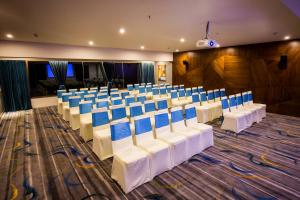 a banquet hall with white chairs and blue seats at The Bheemli Resort Managed by AccorHotels in Visakhapatnam +36 photos
