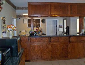 a kitchen with wooden cabinets and a microwave at America's Best Inn - Brinkley in Brinkley