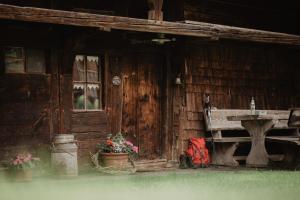 a wooden house with a bench and a table at Romantisches Schwarzwälder Bauernhäuschen Hüsli am Griesbachhof in Titisee-Neustadt