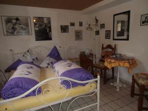 Schlafzimmer mit einem Bett mit lila und weißen Kissen in der Unterkunft Gästehaus Baur in Kappel-Grafenhausen