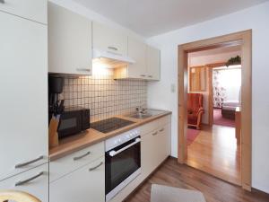 a kitchen with white cabinets and a stove top oven at Chalet in Vent near Stablein Ski Lift in Vent +20 photos