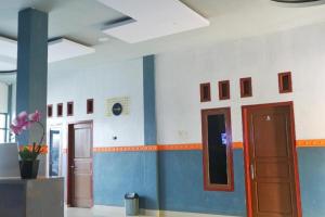 a room with blue and white walls and a door at Penginapan Arsyana in Tamperan