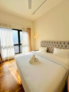 ein großes weißes Bett in einem Zimmer mit einem großen Fenster in der Unterkunft The Mews Luxury Apartment By KLCC in Kuala Lumpur