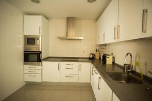 a kitchen with white cabinets and a sink at Soho Lounge - Space Maison Apartments in Seville +20 photos