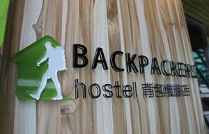a sign on the side of a wooden door at Backpackers Hostel - Taipei Changchun in Taipei