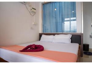 ein Bett mit einer roten Decke darauf und einem Fenster in der Unterkunft Ocean View in Port Blair