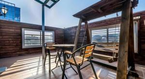 a porch with two chairs and a table on a balcony at Hotel Russo (Korea Quality) in Yuch'ŏn-dong