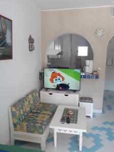 a living room with a couch and a flat screen tv at Golden Tulip in Sousse