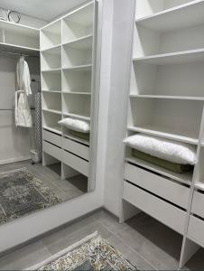 a walk in closet with white shelves and a mirror at Квартира,Еврейская,1 in Bilhorod-Dnistrovskyi