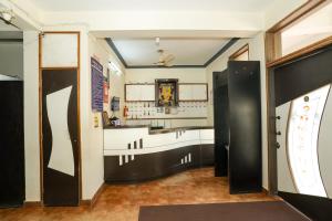 a kitchen with black and white walls and floors at Shwetha Lodge in Kollūru