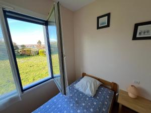 a small bedroom with a bed and a window at lambezen Notinau, vue mer, plages à proximité in Camaret-sur-Mer