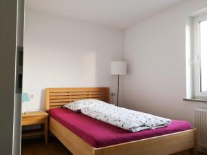 a bedroom with a wooden bed with a purple mattress at Focus Bodensee in Lindau