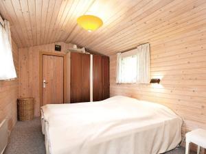 a bedroom with a bed in a wooden room at 6 person holiday home in Dannemare in Dannemare
