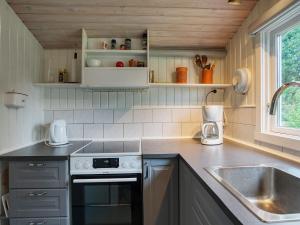 a small kitchen with a sink and a stove at 6 person holiday home in Dannemare in Dannemare
