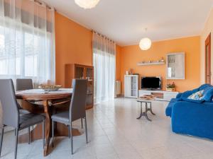 a living room with a table and a blue couch at Etna & Sea View Apartment in Giarre