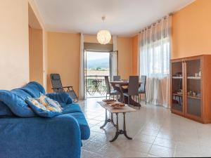 a living room with a blue couch and a table at Etna & Sea View Apartment in Giarre