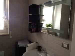 a bathroom with a sink and a mirror and a window at Sweet Holiday Home in Bernalda