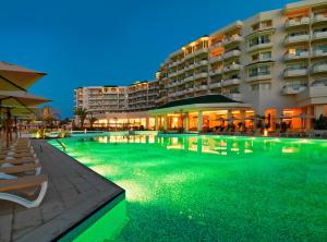 a swimming pool in front of a hotel at night at Iberostar Selection Royal El Mansour in Mahdia