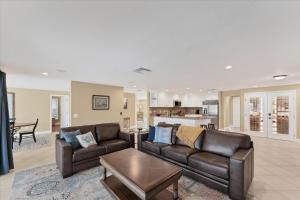 a living room with two leather couches and a kitchen at GRH14784 - Charlotte County - 4 Bed 2 Baths House in Punta Gorda Isles