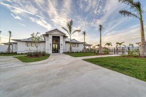 Una casa con palmeras y una entrada para coches. en GRH14800 - Charlotte County - 2 Bed 2 Baths Condo, en Tropical Gulf Acres