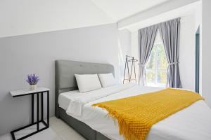 ブリンチャンにあるFamily Homestay In Emerald Avenue Apartment Clover Home 3-22のベッドルーム1室(黄色い毛布付きのベッド1台付)
