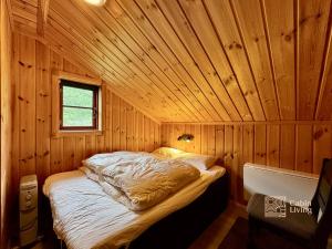 a bedroom with a bed in a wooden cabin at Modern cabin sauna, BBQ & beautiful view Filefjell in Tyinkrysset