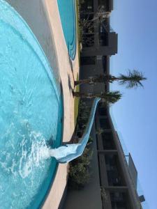 a swimming pool with a slide next to a building at Pebble Beach 204 in Sibaya +1 photo